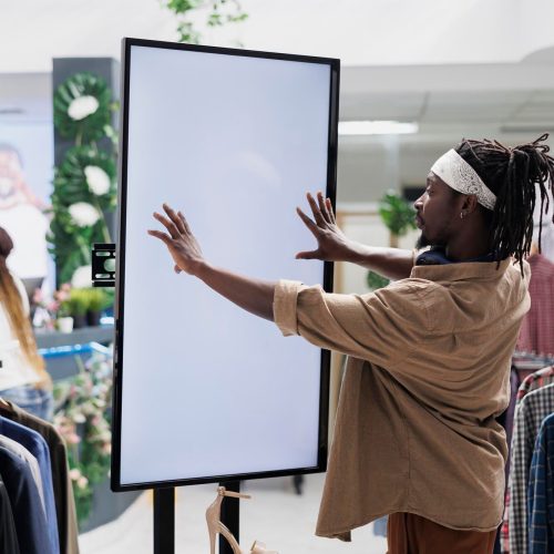 man-interacting-with-digital-screen-offering-shoes-customer_482257-84187